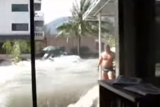 En svensk man står i ett hotell och filmar vattenmassorna som forsar in över Phuket, Thailand.